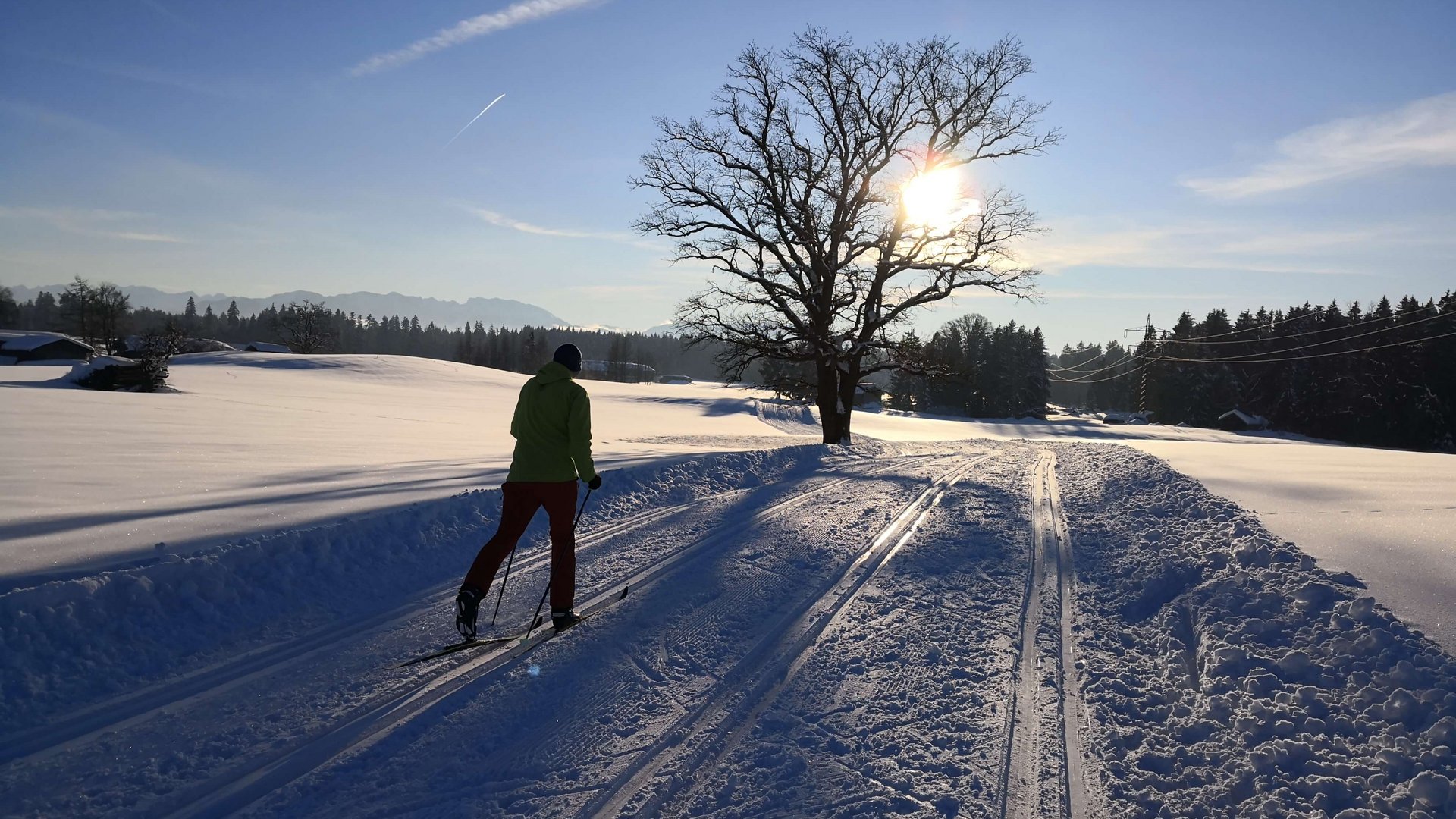 Winterurlaub in Bayern im BERGEBLICK Person beim Langlauf auf verschneiter Loipe bei Sonnenuntergang