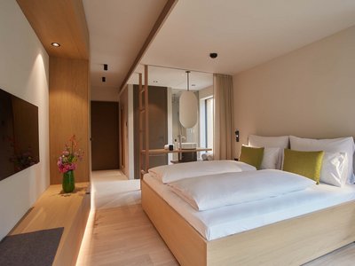 The adult-only hotel in Bavaria, Germany Modern hotel room with double bed, TV, and washbasin area